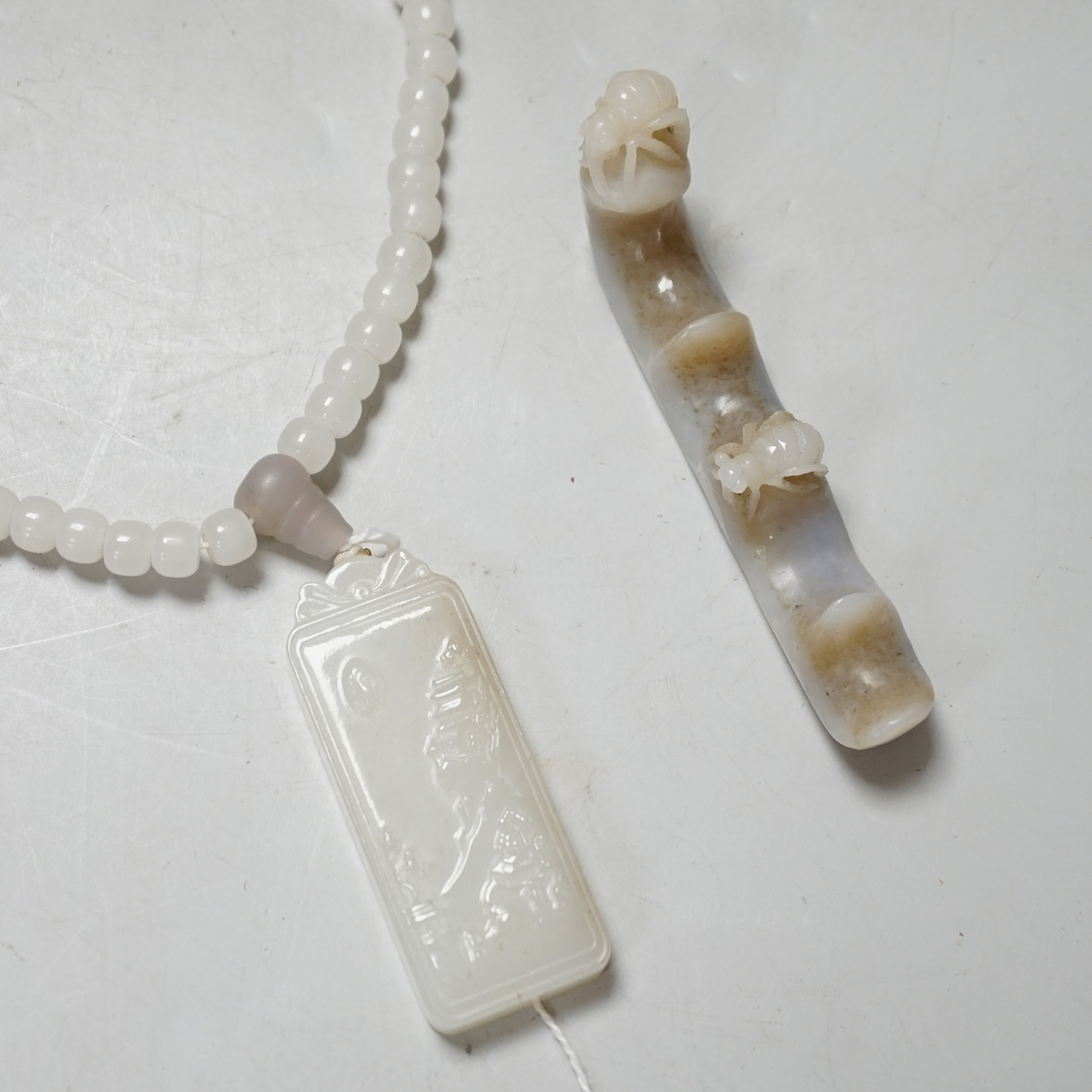 A Chinese white jade pendant and a jade brush rest